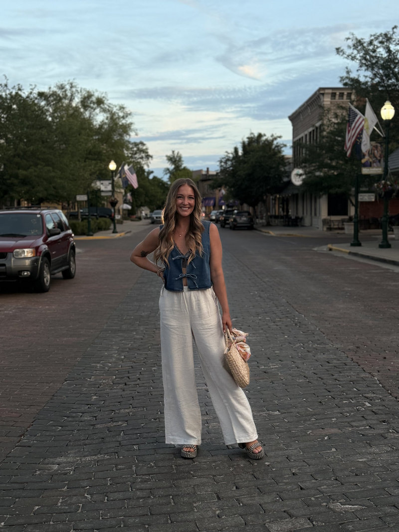 Liz standing on a brick main street in small town Indiana at dusk