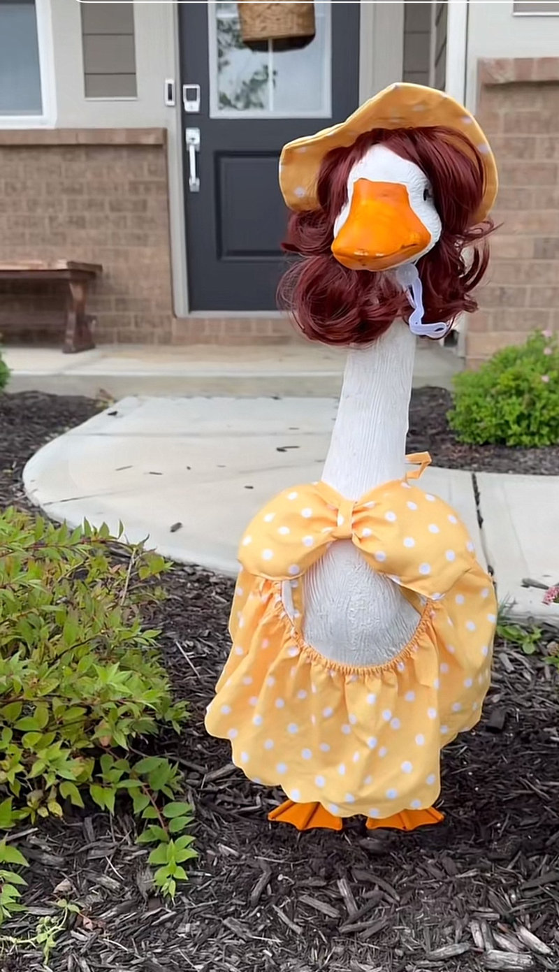 Lucy Goosey the porch goose in a yellow polka dot dress and bonnet